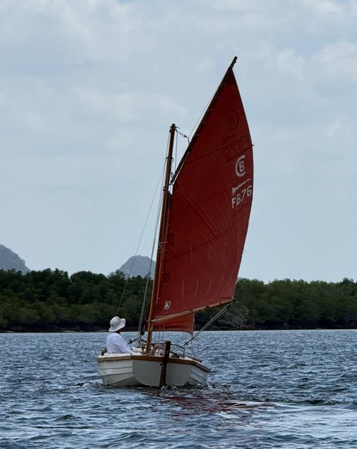 Post Boat sailing with distant hills beyond the Krabi estuary