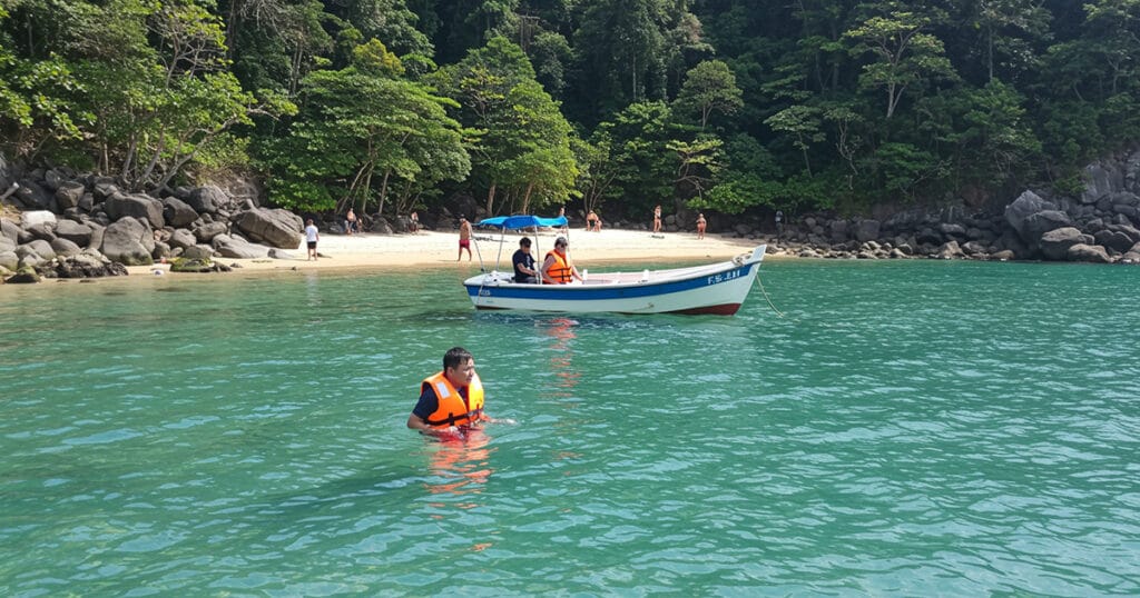 A refreshing swim stop in clear, shallow waters during a family boat trip in Krabi's quiet coastal areas.